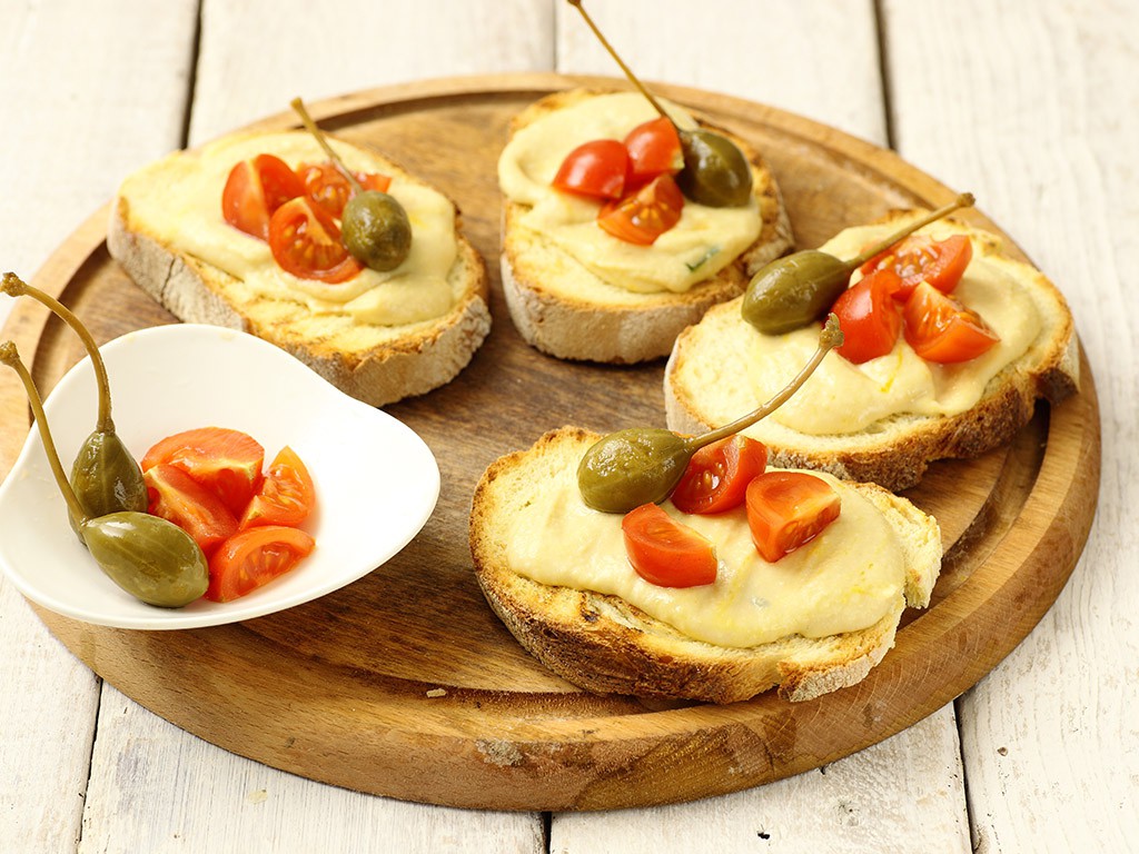 Pane lungo a fette con Crema di Ceci Valfrutta Granchef, Prezzemolo e Frutti di Cappero Valfrutta Granchef